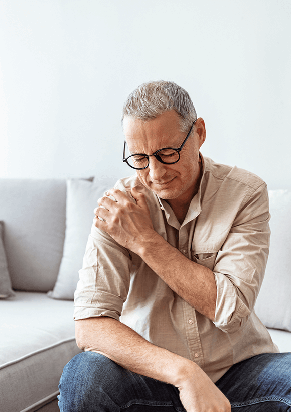 man holding shoulder due to severe shoulder pain