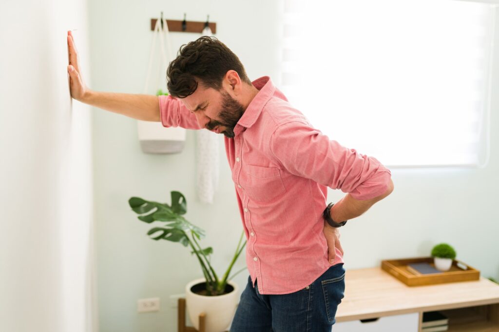 Man Holding Lower back due to pain in facet joints